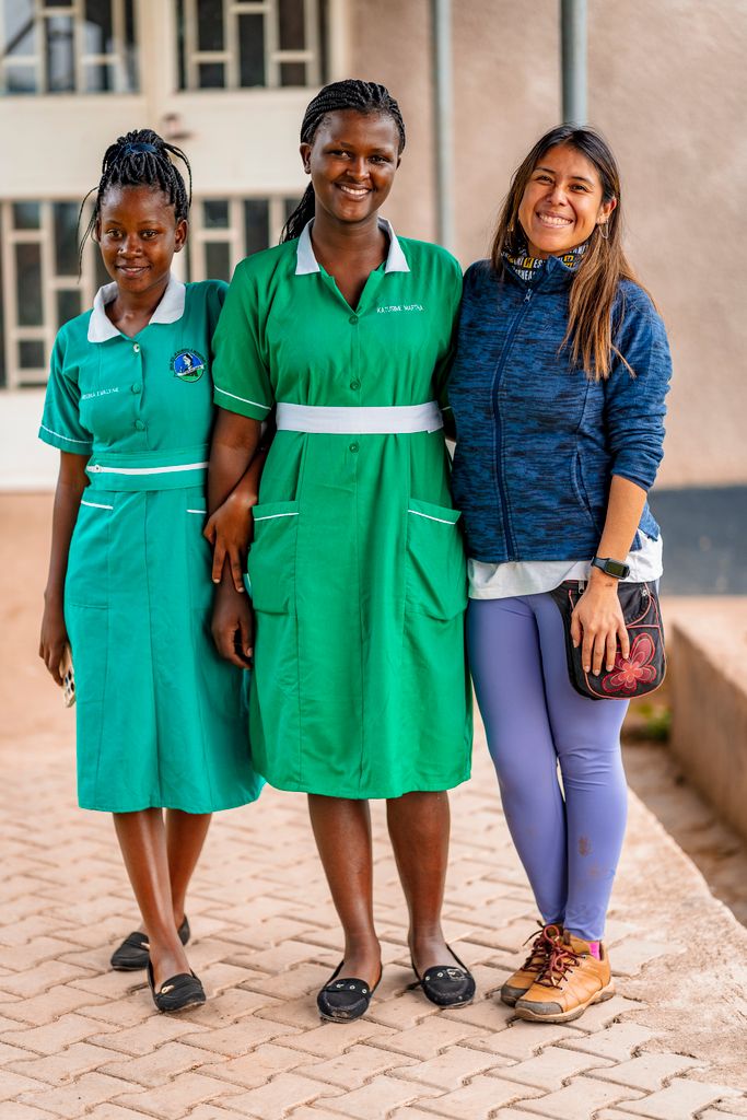 Two nurses and a woman smiling warmly outside a local hospital.